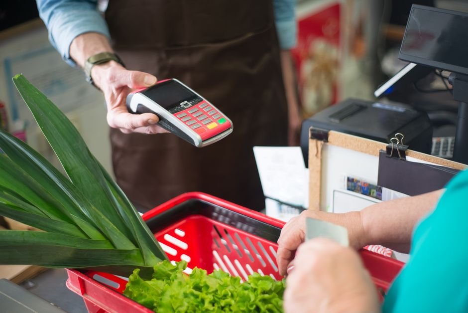 Vendedora de loja de roupas atendendo cliente no caixa, simbolizando o momento em que a comissão de venda se torna devida