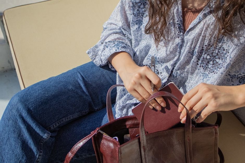 Funcionária de loja mostrando o conteúdo da bolsa para conferência na saída do estabelecimento